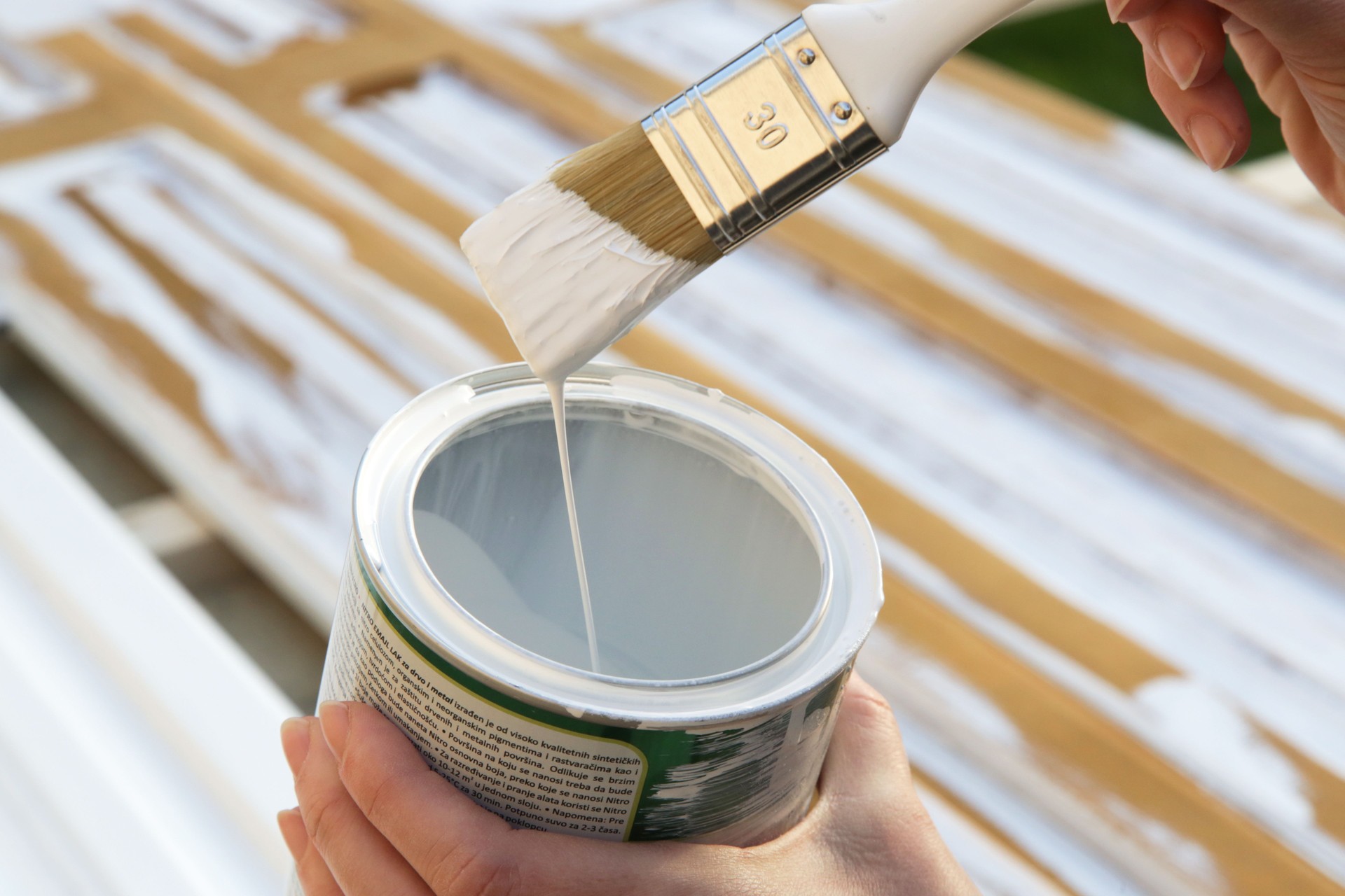 Process of painting wooden door with a paintbrush with white color, DIY house improvement project.
